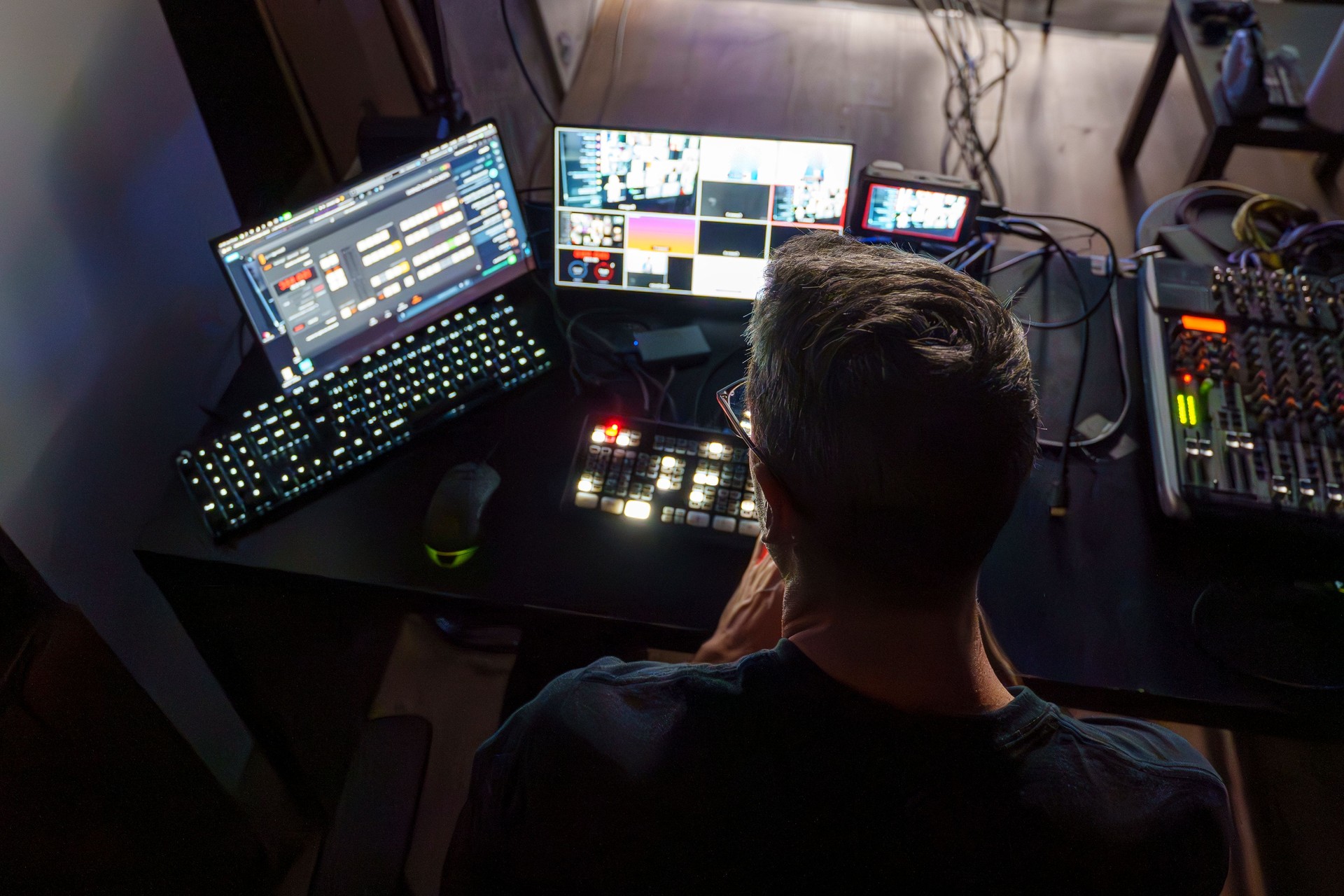 Video Director Managing Multiple Screens and Equipment in a Control Room During a Live Broadcast